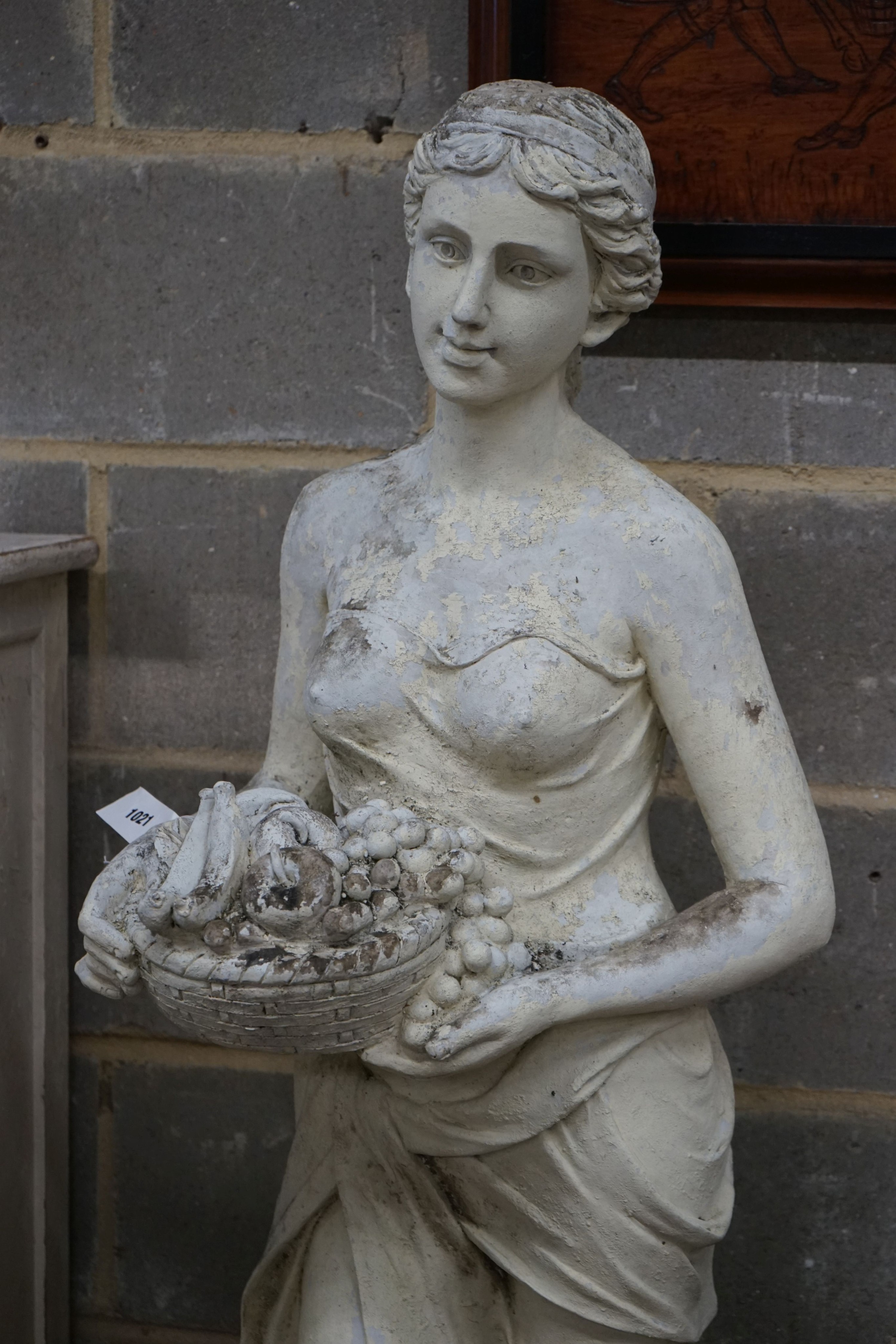 A large painted composition faux marble garden ornament, modelled as a girl with basket of fruit, height 160cm